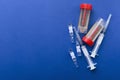 Top view of ampules, syringes and plastic urine containers with samples on the dark blue background.Empty space for text.Concept o Royalty Free Stock Photo