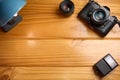 Top view of analog camera, flash and lens on wooden table, professional photography equipment. Photography background with copy sp Royalty Free Stock Photo