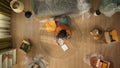 Top view of apartment living room. Man sitting on the floor reading eviction and bill debt papers, depressed shocked Royalty Free Stock Photo