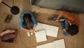 Top view of apartment living room. Man and woman assembles furniture, woman sits upset man looking at furniture details. Royalty Free Stock Photo