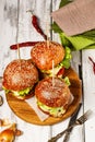 Top view appetizing chicken burger with cheese, fresh salad and vegetables on a round cutting board