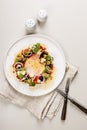 Top view appetizing and fresh vegetable salad with beetroot, goat cheese, ripe tomato, cucumber, mustard leaves and spicy sauce