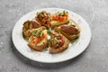 Top view on appetizing italian appetizers bruschettas on a white plate, horizontal Royalty Free Stock Photo