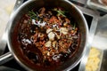 top view of appetizing sauce with slices of chili garlic and sprigs of rosemary