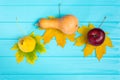 Top view of an apple, a pear and pumpkin lying on leaves on blue Royalty Free Stock Photo