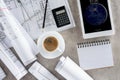 top view of architect workplace with coffee cup blueprints calculator and ipad tablet