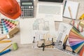 Top view of architects drawing modern house with sample material, hardhat, laptop on creative table