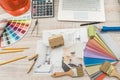 Top view of architects drawing modern house with sample material, hardhat, laptop on creative table