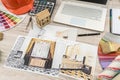 Top view of architects drawing modern house with sample material, hardhat, laptop on creative table