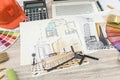 Top view of architects drawing modern house with sample material, hardhat, laptop on creative table