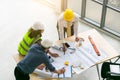 Top view of architects and engineers to discuss and create a blueprint to build a modern and make suggestions during construction