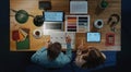 Top view of architects working on computer at desk with paperwork in home office. Royalty Free Stock Photo