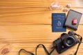 Top view of Argentine passport and travel accessories on table. Camera, wallet, miniature suitcase and embarkation, and seashells.