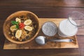 Top view of arranged chia seeds with milk and oatmeal porridge with banana pieces for breakfast on wooden tabletop