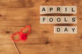 top view of arranged wooden cubes in april fools day lettering with party eyeglasses and clown nose on wooden tabletop, 1 april ho