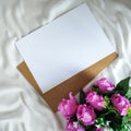 Top view of artificial bouquet and blank paper on the white piece of cloth Royalty Free Stock Photo