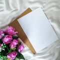 Top view of artificial bouquet and blank paper on the white piece of cloth Royalty Free Stock Photo