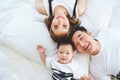 Top view of Asian family with father mother and son on white pillow bed in bedroom at home. Happy parents and child baby concept. Royalty Free Stock Photo