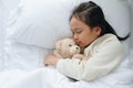 Asian little girl sleeping and hug teddy bear in the bedroom Royalty Free Stock Photo