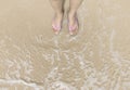 Top view of Asian woman feet wearing a pink slipper on ocean sandy beach