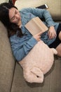 top view of Asian young woman holding book and sleeping on sofa bed. girl take a nap in living room Royalty Free Stock Photo