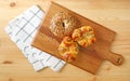 Top view of assorted breads on the wooden breadboard with kitchen cloth Royalty Free Stock Photo