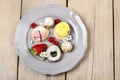 Top view of assorted cookies and fruits on grey ceramic plate