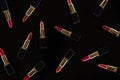 Top view of assorted lipsticks in luxury tubes isolated on black