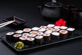 Top view assorted sushi set on a black on plate, dark background. Asian food restaurant delivery, platter set. Japanese classic Royalty Free Stock Photo