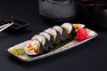 Top view assorted sushi set on a black on plate, dark background. Asian food restaurant delivery, platter set. Japanese classic Royalty Free Stock Photo