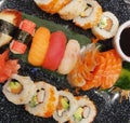 Top view of assorted sushi and soy sauce on dark platter Royalty Free Stock Photo