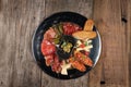 Top view of an assortment of cold appetizers served on a black plate