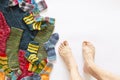 Colorful woolen socks and a pair of legs on white background Royalty Free Stock Photo