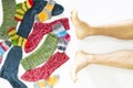 Colorful woolen socks and a pair of legs on white background Royalty Free Stock Photo