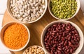 Top view of assortment of peas, lentils, beans and legumes over wooden background