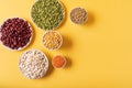 Top view of assortment of peas, lentils, beans and legumes over yellow background