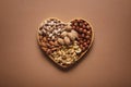 Top view of assortment of various nuts in heart shaped box