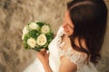 Top view of attractive brunette bride holding wedding bouquet. White roses flowers. Evening light on sandy beach Royalty Free Stock Photo