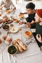 Top view of attractive group of international friends sitting at the table full of food eating together. Young Royalty Free Stock Photo