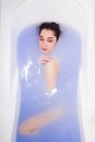 Top view of attractive young woman keeping eyes closed while enjoying luxurious bath