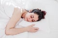 Top view of attractive young woman sleeping well in bed hugging soft white pillow. girl resting, good night sleep concept. Lady Royalty Free Stock Photo