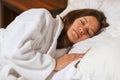 Top view of attractive young woman sleeping well in bed hugging soft white pillow. Teenage girl resting, good night sleep concept. Royalty Free Stock Photo