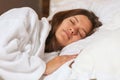 Top view of attractive young woman sleeping well in bed hugging soft white pillow. Teenage girl resting, good night sleep concept. Royalty Free Stock Photo