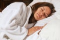Top view of attractive young woman sleeping well in bed hugging soft white pillow. Teenage girl resting, good night sleep concept. Royalty Free Stock Photo