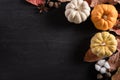 Top view of  Autumn maple leaves with Pumpkin and red berries on black wooden background. Thanksgiving day concept Royalty Free Stock Photo