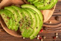 top view of avocado sandwiches with cutted rye bread and sprinkle with pepper on wooden background, healthy lifestyle