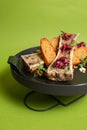 Top view of baked bone marrow with bread and herbs on a black plate on a green background Royalty Free Stock Photo