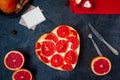 Top view baked cheesecake with red grapefruit slices in the shape of heart on the black stone background, postcard for wishes, fre Royalty Free Stock Photo