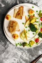 Top view baked sea fish fillet with vegetables. Tilapia fillet with broccoli, cherry tomatoes, fried potatoes, green peas Royalty Free Stock Photo