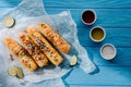 top view of baking paper with grilled corn near chili spice oil and salt on wooden Royalty Free Stock Photo